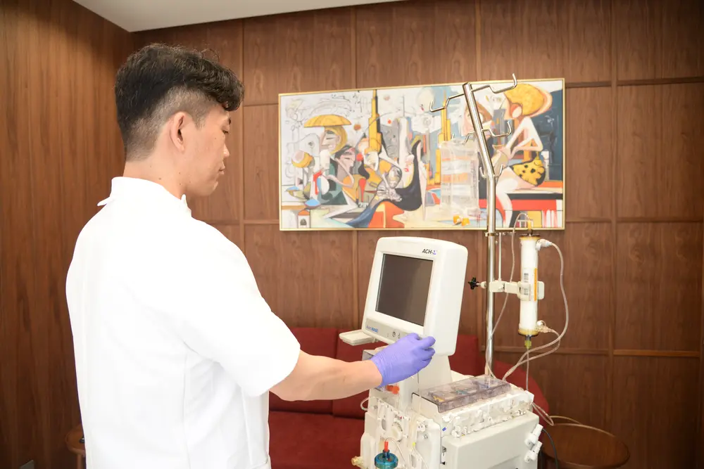 A member of our staff operating the ACH-Σ blood purification device in the treatment room